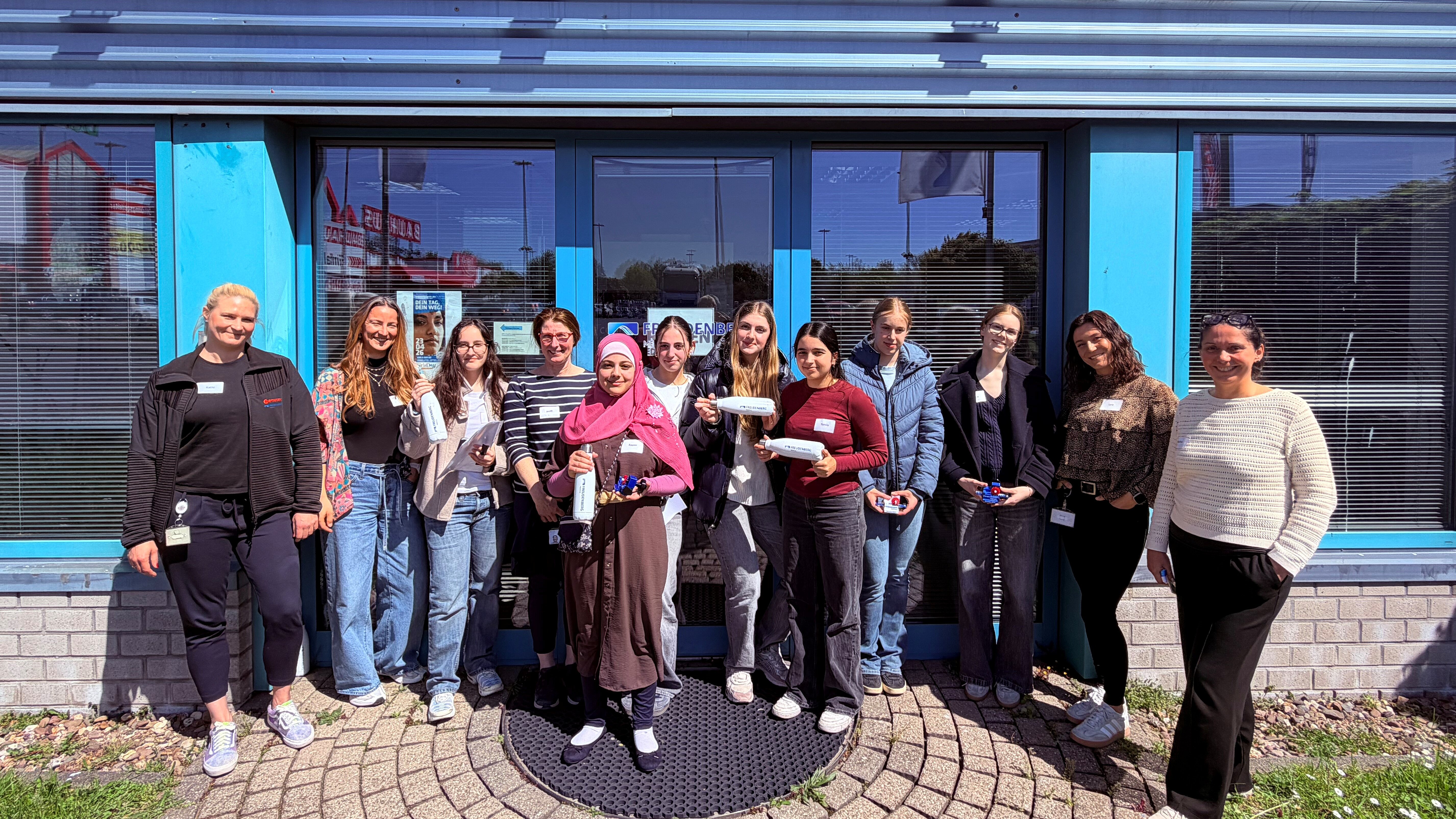 Gruppenbild mit jungen Mädchen, die vor einem Gebäude stehen