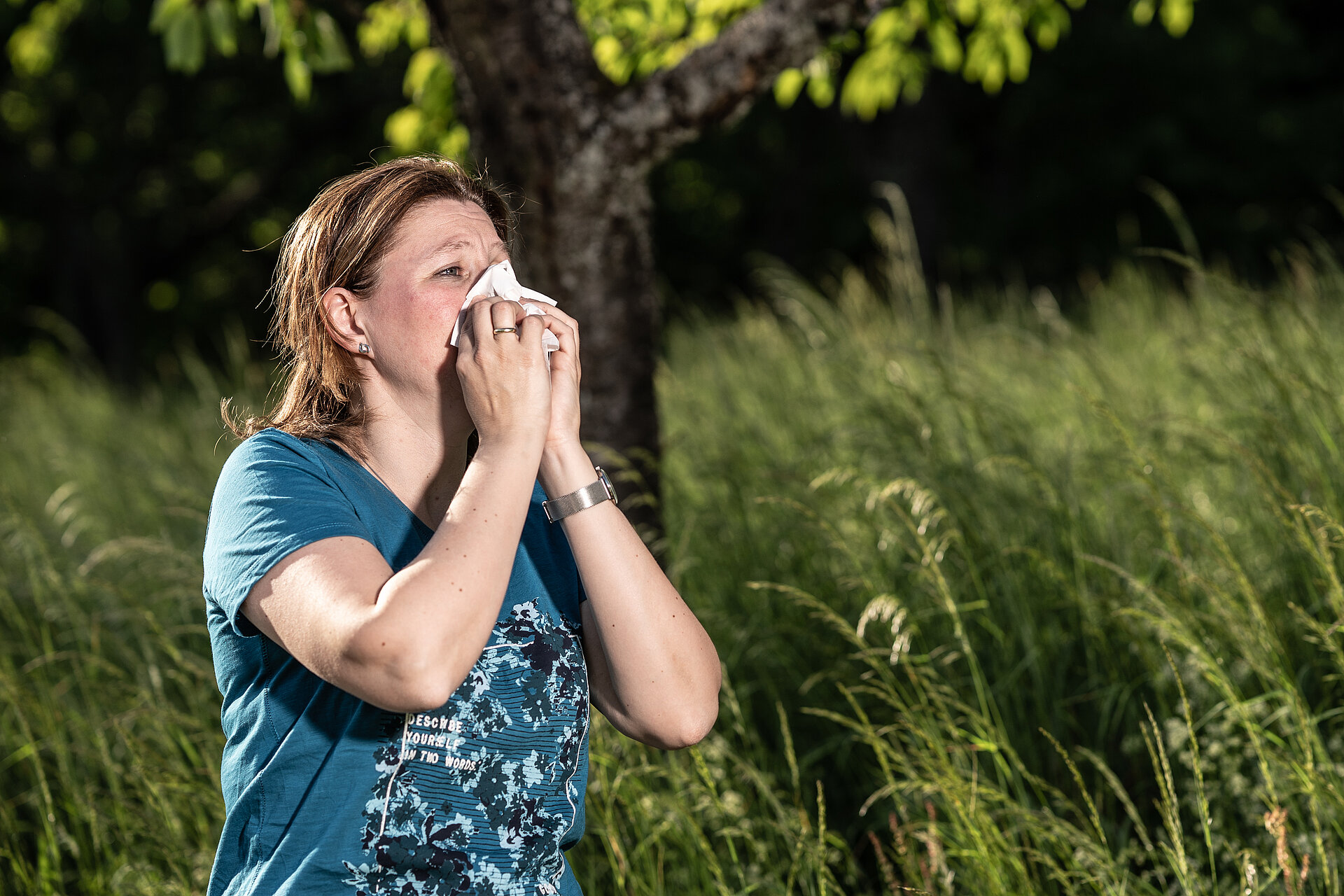 Woman sneezing because of allergy.